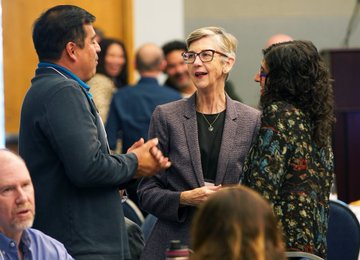 Three conference attendees speak with one another at the gathering