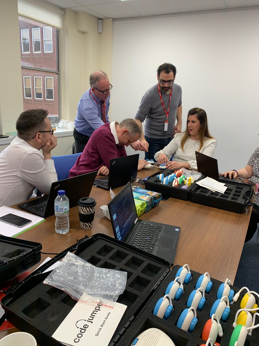 A group of adults talking and working with Code Jumper