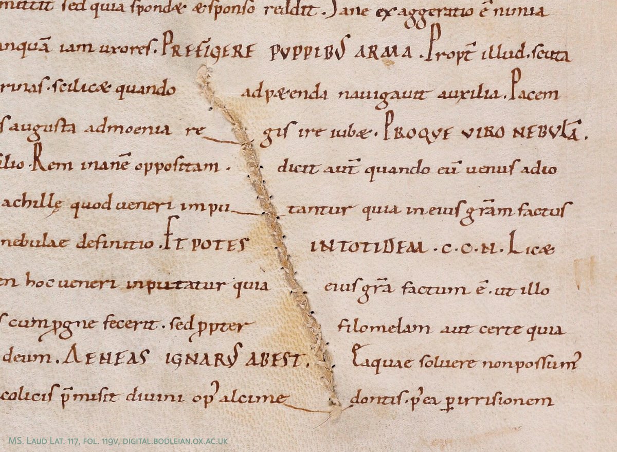 Detail from a medieval manuscript page, with damaged parchment repaired with thread.