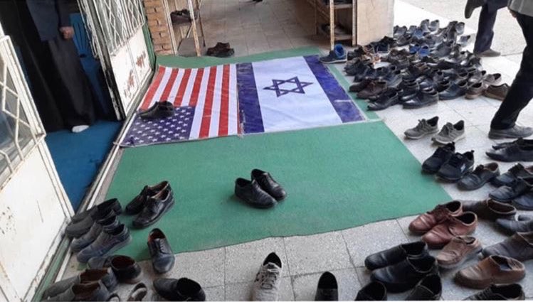 HananyaNaftali's tweet photo. The Islamic regime in Iran has placed flags of US &amp; Israel at the entrance to a mosque.

What we are seeing here is amazing. Even religious Muslims in Iran REFUSE to put their shoes on the flags. #IranProtests2020 https://t.co/tCqCWS83Uw