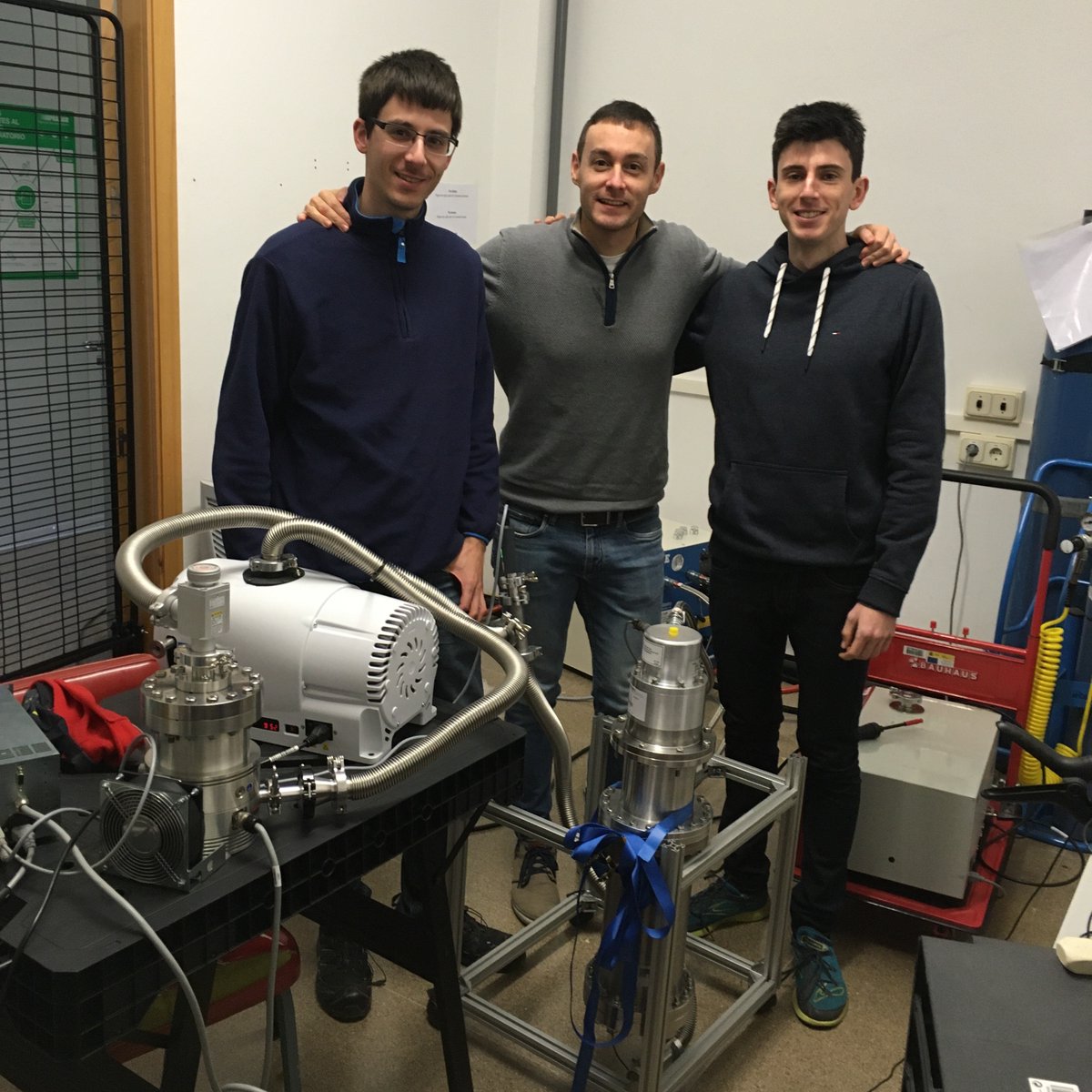 PetaloThe's tweet photo. Marc, Alberto and Dani with the cryocooler already connected and cooling down! We're testing the different parts of the cryostat, before assembling it. https://t.co/mqMfwtTcoP