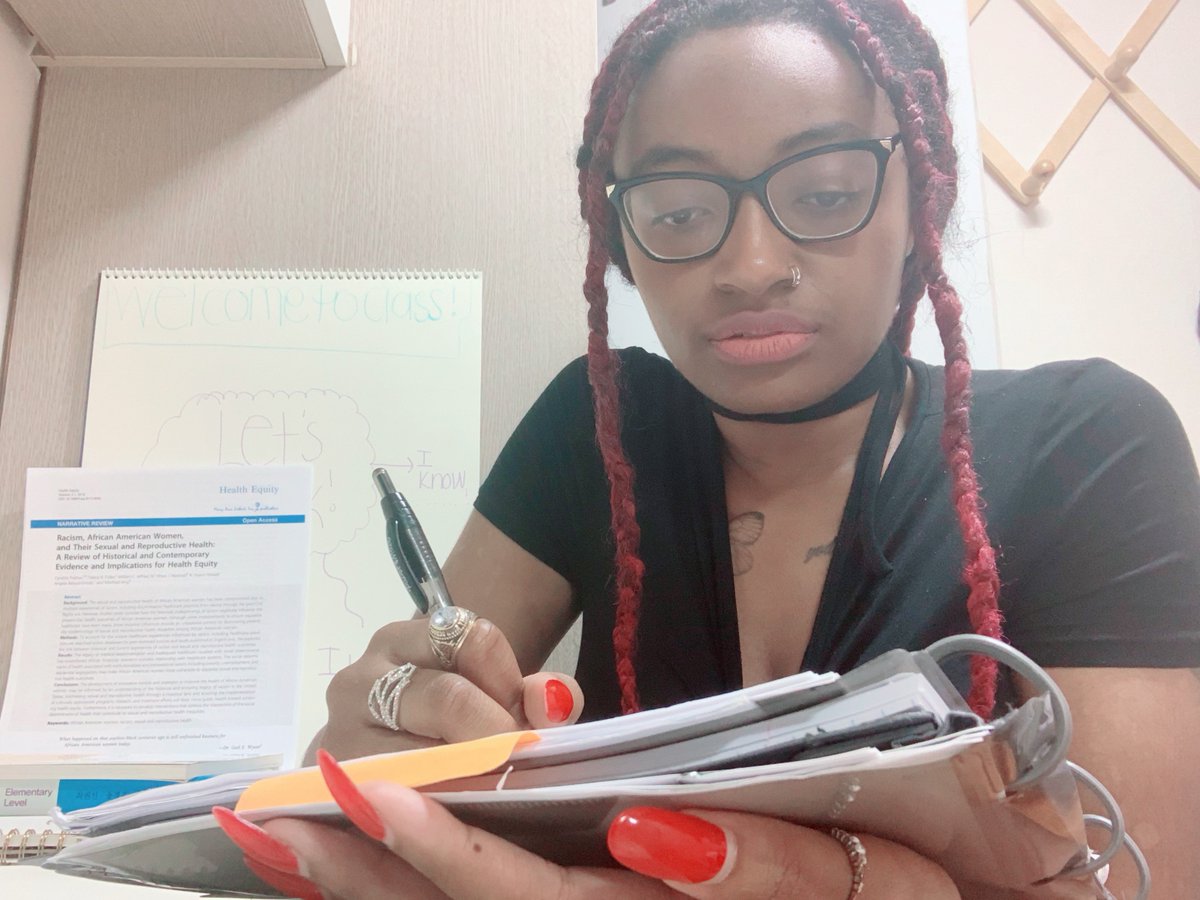 Curtissa sitting at her desk writing in a notebook.