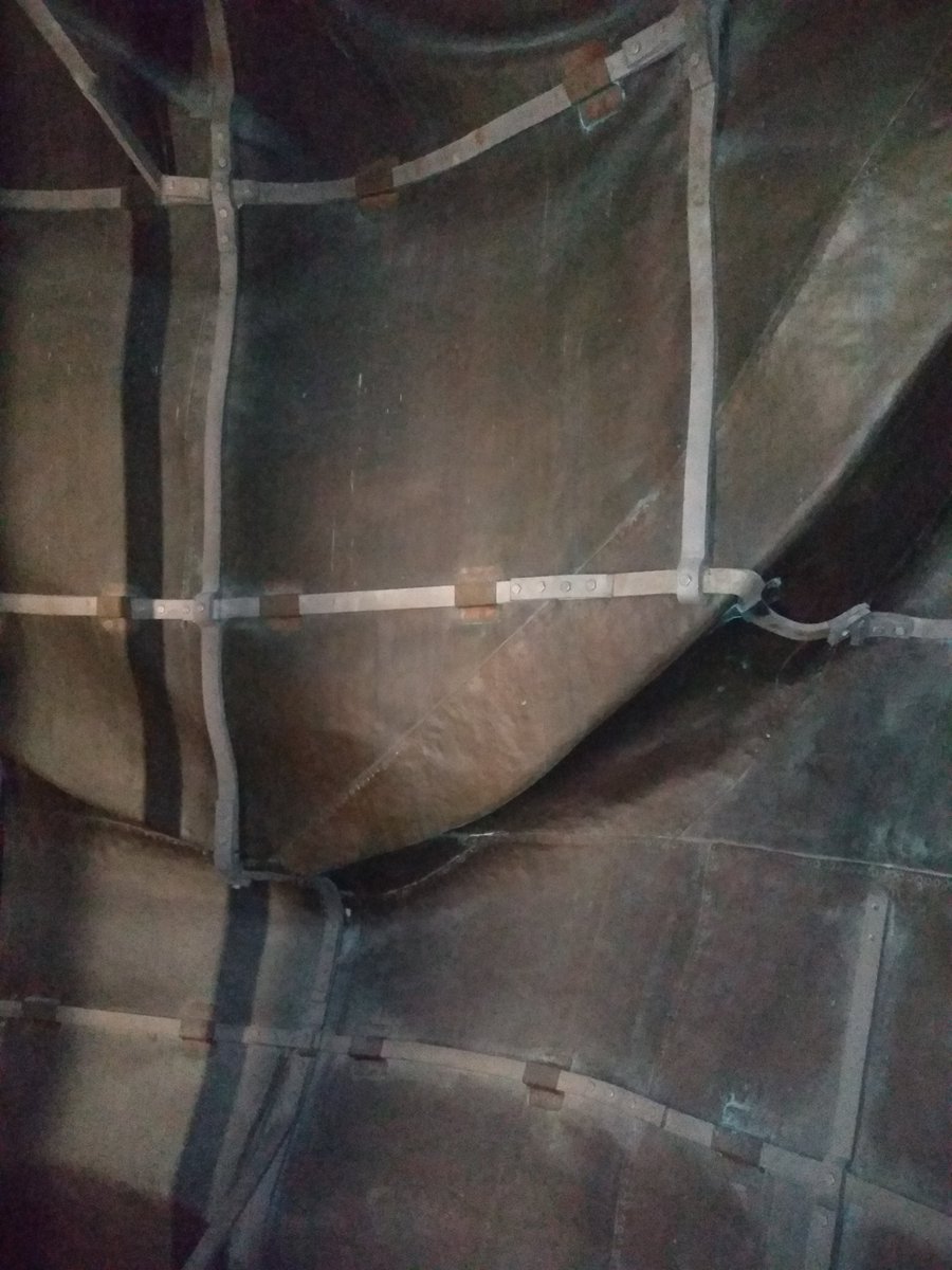 Close up photo of the inside of the Statue of Liberty featuring the copper skin and several armature bars.  