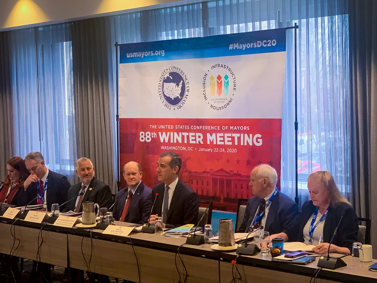 A panel of governmental officials seated at a long table