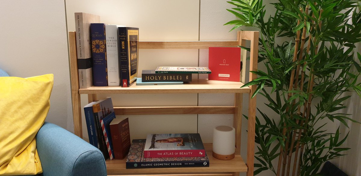 A small room with an armchair, throw cushions, a beanbag, rug, bookcase and pot plant. Close up of the book case showing a variety of religious texts, Scottish landscape photo books and design books.