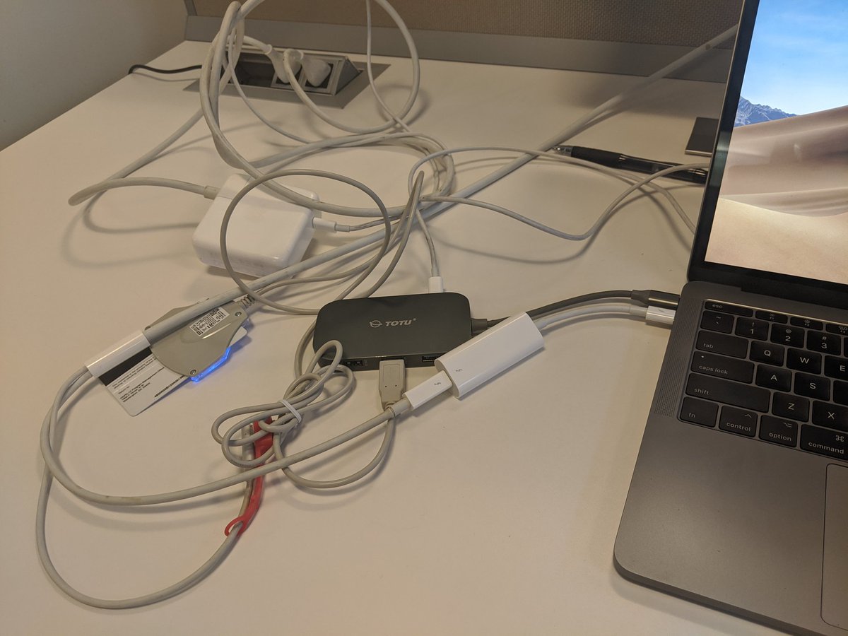 Tangle of cables and adapters plugged into a laptop