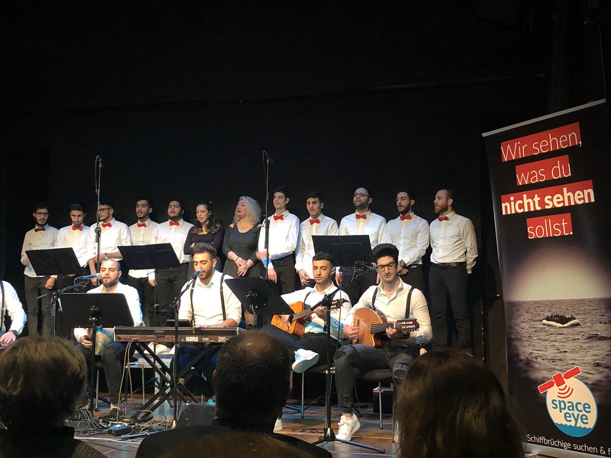 AnnieMuc's tweet photo. Der syrische Friedenschor singt bei der Verleihung des Georg-Elser-Preises der @StadtMuenchen an den Seenotretter Michael Buschheuer. @seaeyeorg. Weil jedes Leben zählt und Menschen wie Michael Buschheuer Leben retten. ❤️ Mit @Vorlaender_Muc und Marian #Offman. https://t.co/DZ3wwPg7Cv