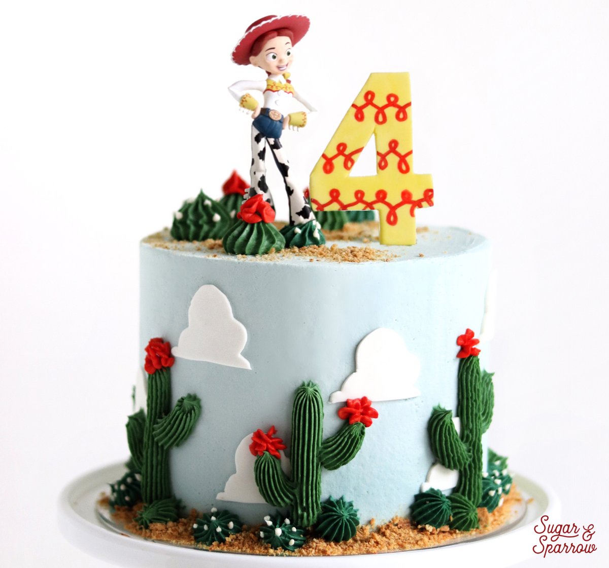 sugarandsparrow's tweet photo. My sweet niece requested a "Jessie Cake" for her birthday, so I put a Western twist on this #ToyStory cake and added buttercream piped #cactus, fondant clouds, edible (graham cracker) sand, and topped it all with a Jessie figurine. Perfect for this little @disney @pixar lover! https://t.co/gCgLy0cMZV