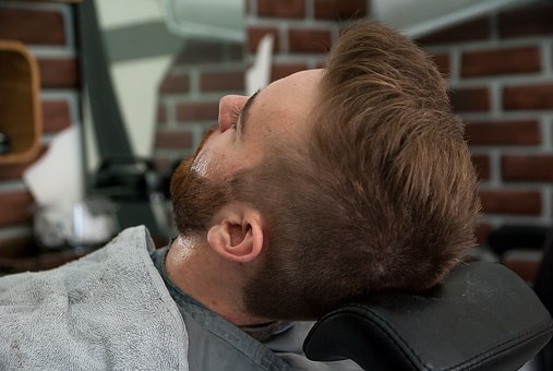 Bearded man awaits shave in a barber's chair