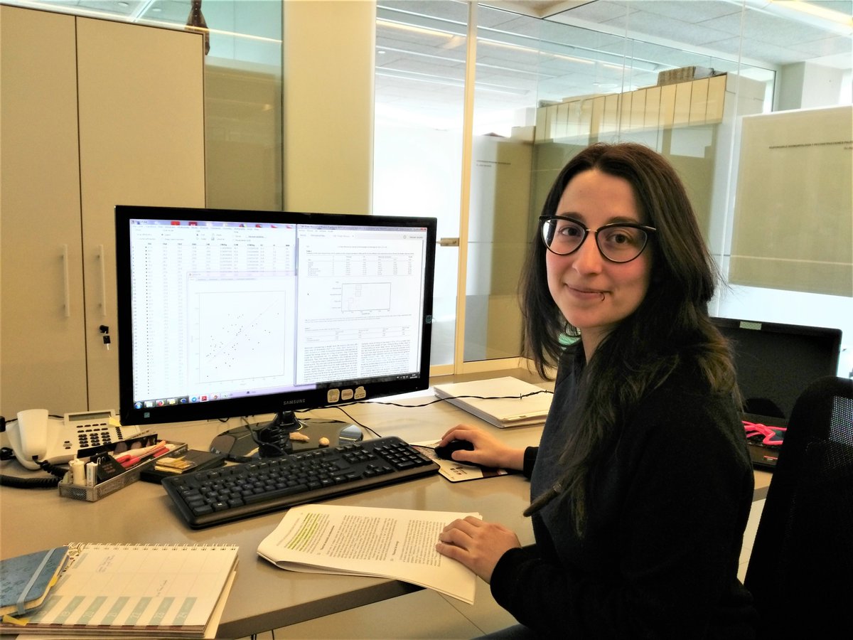 Olalla siting at her desk in front of her computer.
