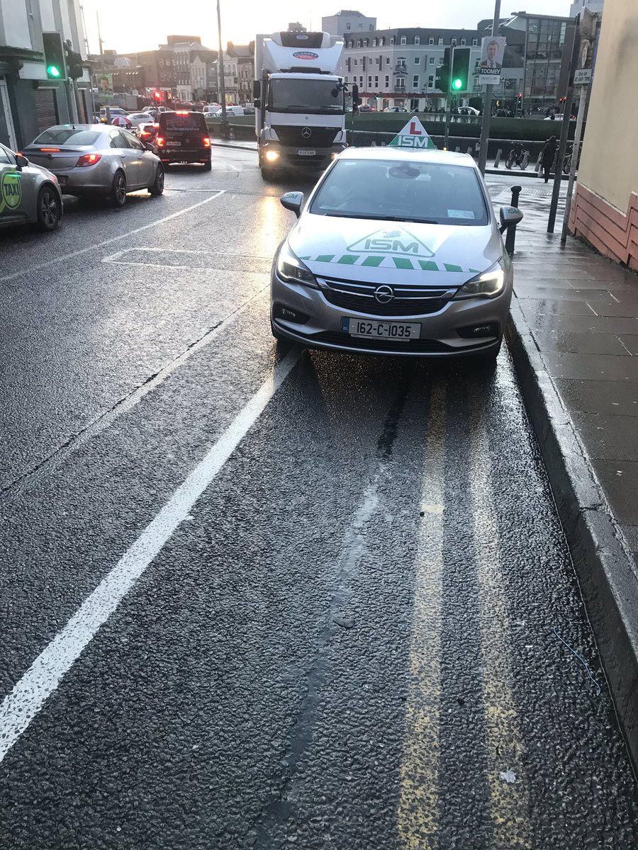 DBeechinor's tweet photo. Instructor in passenger seat writing notes for driver student, didn’t care that I had to cycle out on the road to pass. Well done ISM. @BadParkingCork  @cork_traffic @CorkCyclingCrew @SafeCyclingEire https://t.co/nETrXojjU7
