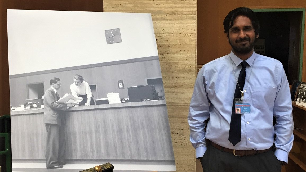 UNOGLibrary's tweet photo. After our annual inventory, the #Library is open again &amp; ready to welcome all visitors. Our 1st client, Mr. Ramaswami from @SwissUMEF, opened his account on the very first morning of Monday, 13 January 2020. Here he's posing w/ our iconic #UNOGLibrary100 anniversary picture! 📸 https://t.co/xo2flPhBJq