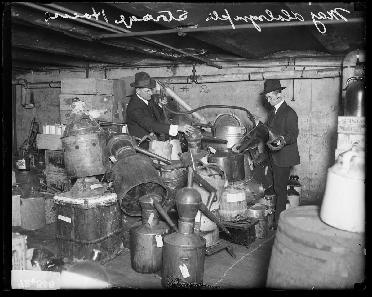 Major A. V. Dalrymple (left), the Supervising Federal Prohibition Director of the Central Department, and an unidentified man sort through liquor distilling equipment seized in raids, Chicago, 1920. 