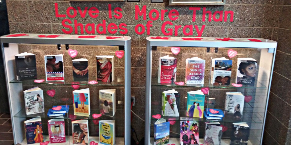 A book display featuring multiple romance books by authors of color. The display is titled "Love Is More Than Shades of Gray."