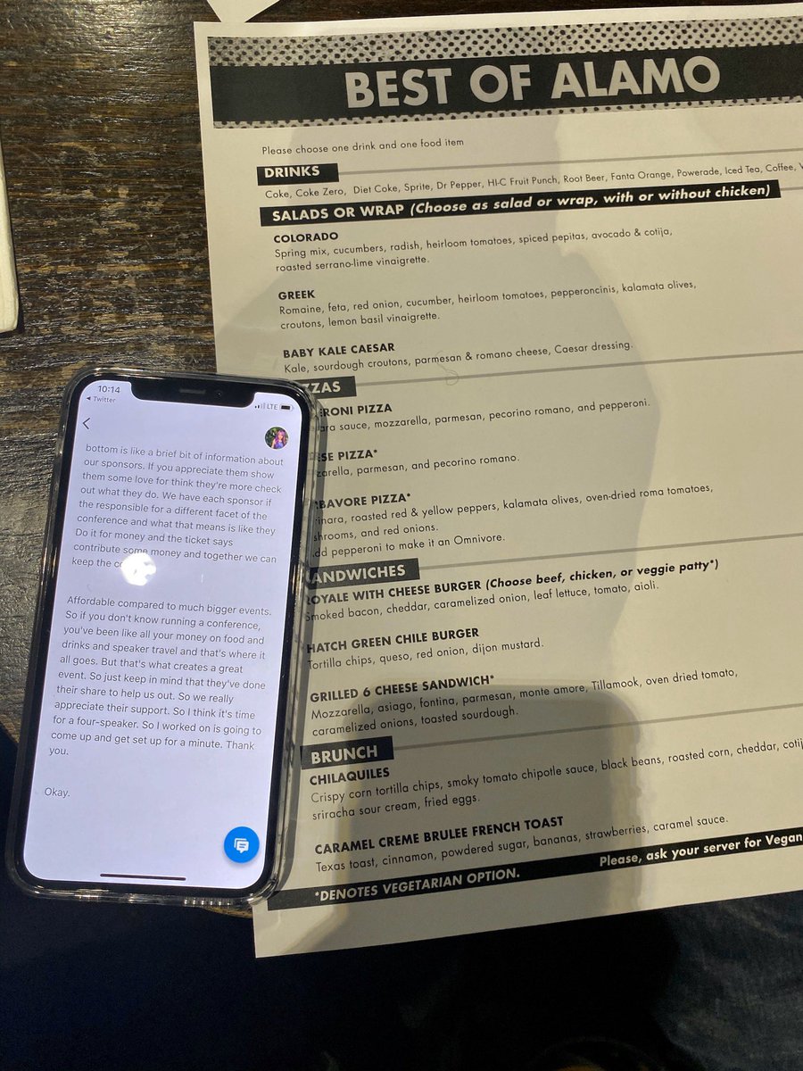 Phone on a table with live transcription on the screen on top of a menu for the Alamo Draft House Theater.