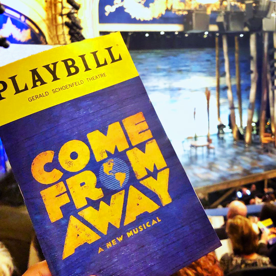 Come From Away playbill in front of the stage