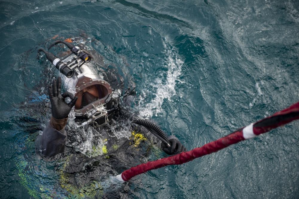 USPACOM's tweet photo. @USPacificFleet Seabees with Underwater Construction Team 2 #UCT2 are performing maintenance on navigational buoys in the harbor at @NBGuam. #Divers #ForgedByTheSea #RM689 #FreeandOpenIndoPacific https://t.co/i8QFga0EwW