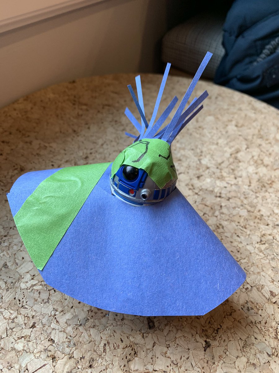 an r2-d2 figurine with blue paper skirt and headdress