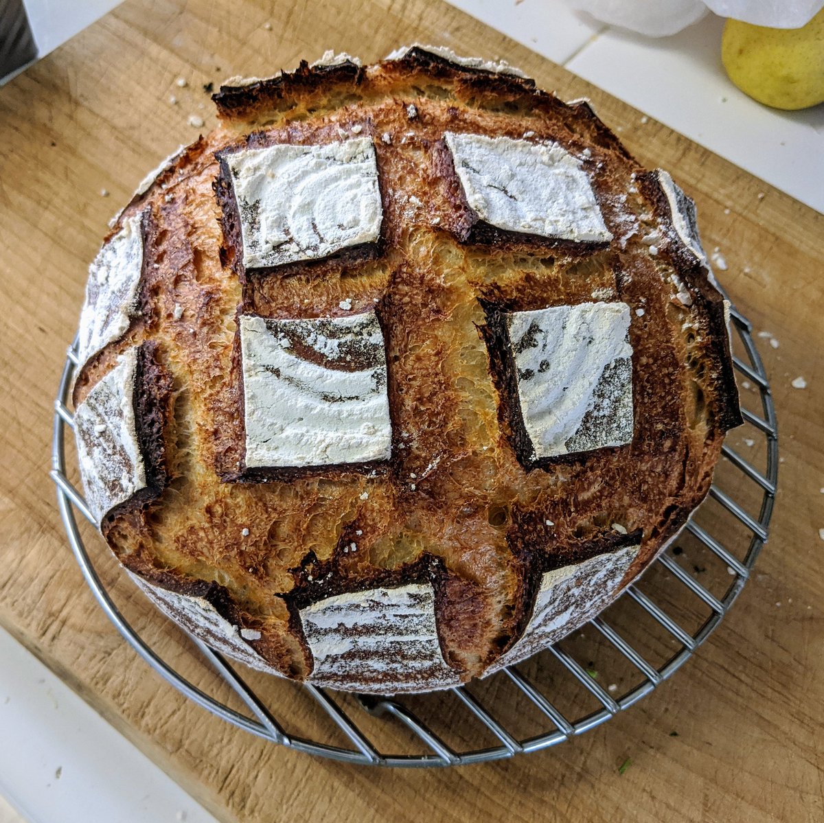 A golden brown boule is slashed in a 3x3 configuration.