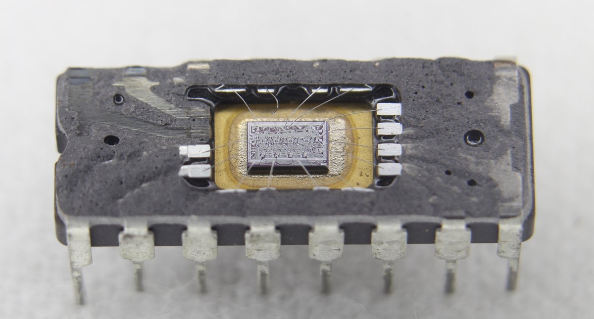 Integrated circuit with the top removed, revealing the tiny die inside.