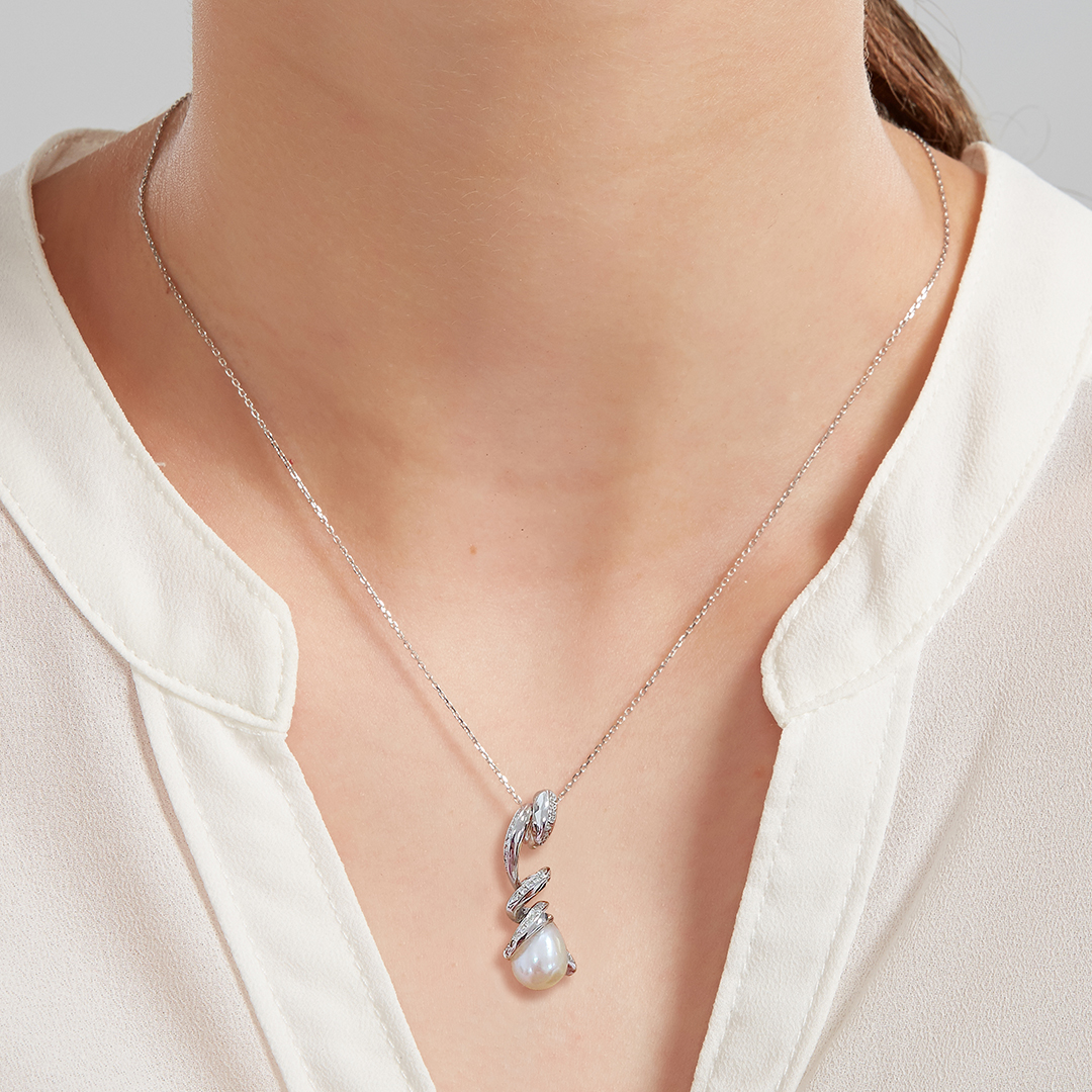 Model wearing Fei Liu's Pirouette Twist Pendant with cubic zirconia and pearl set in sterling silver.