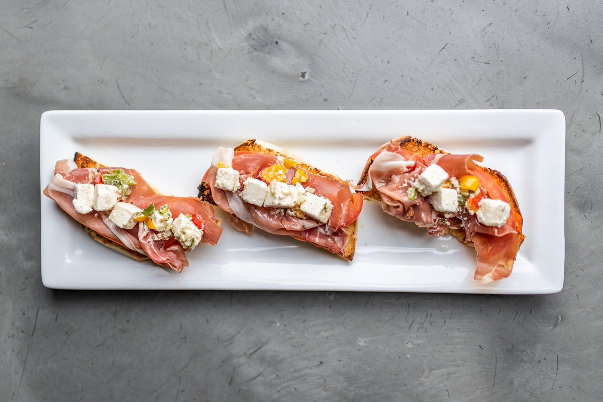 Our classic #bruschetta comes with #prosciutto, seasoned #feta, tomatoes, and #ajvar (roasted red pepper relish) on house-made authentic lepinya bread. ⁣
⁣
Share a plate for 1/2 price during #HappyHour 🍸😎⁣