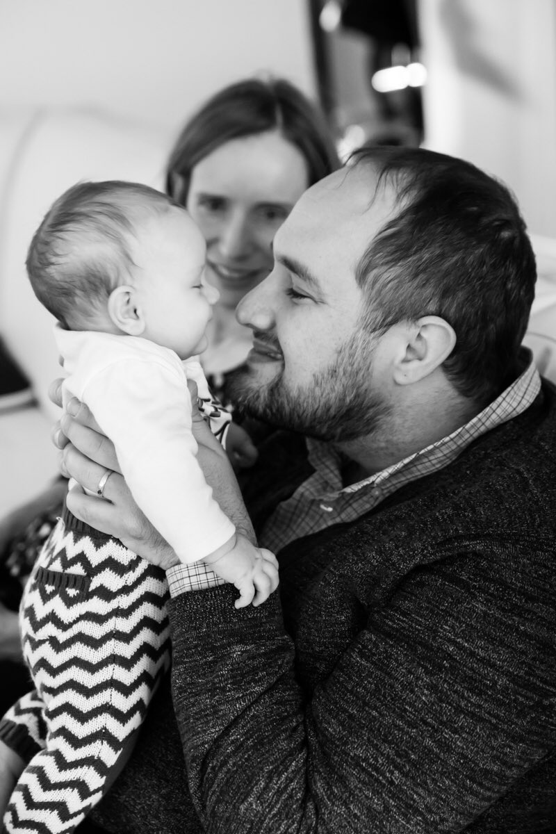 Black and white photo of dad holding baby up
