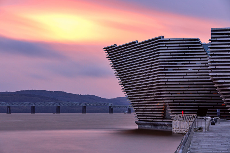 V&A Dundee leaning over the Tay on a purple sunset evening.
