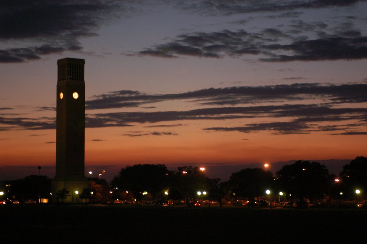 Bell tower at sunset, clock glowing