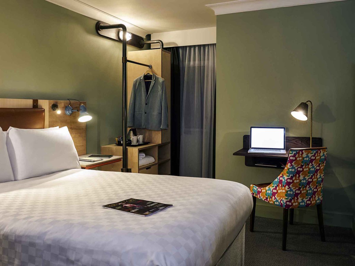 Hotel room at the Bristol Grand Hotel. Includes a double bed, small desk, chair and wardrobe.