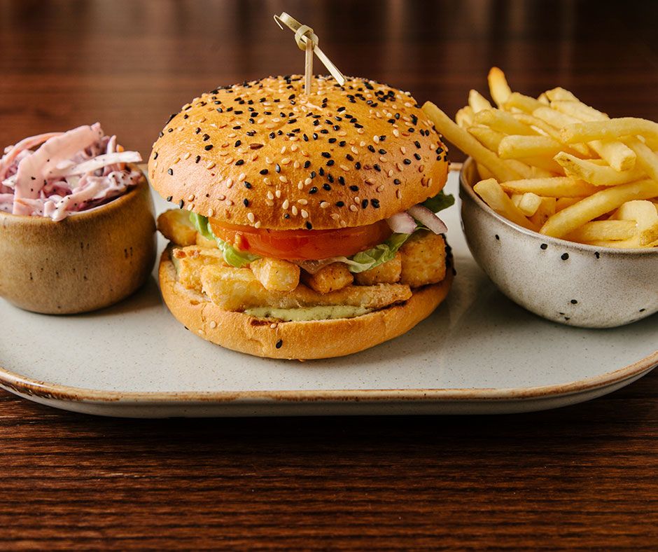 Breaded #halloumi and pesto mayo with gem lettuce and sliced tomato and onion in a brioche bun and served with sides of homemade slaw and skin on fries 😋