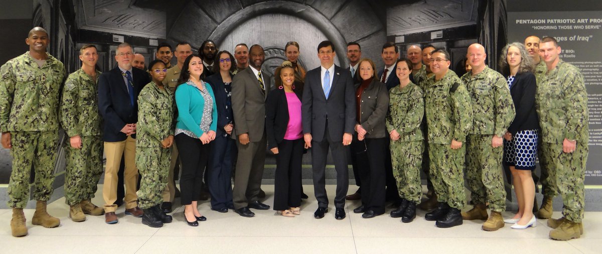 Defense Secretary Esper poses with a group of sailors and civilians at the Pentagon.