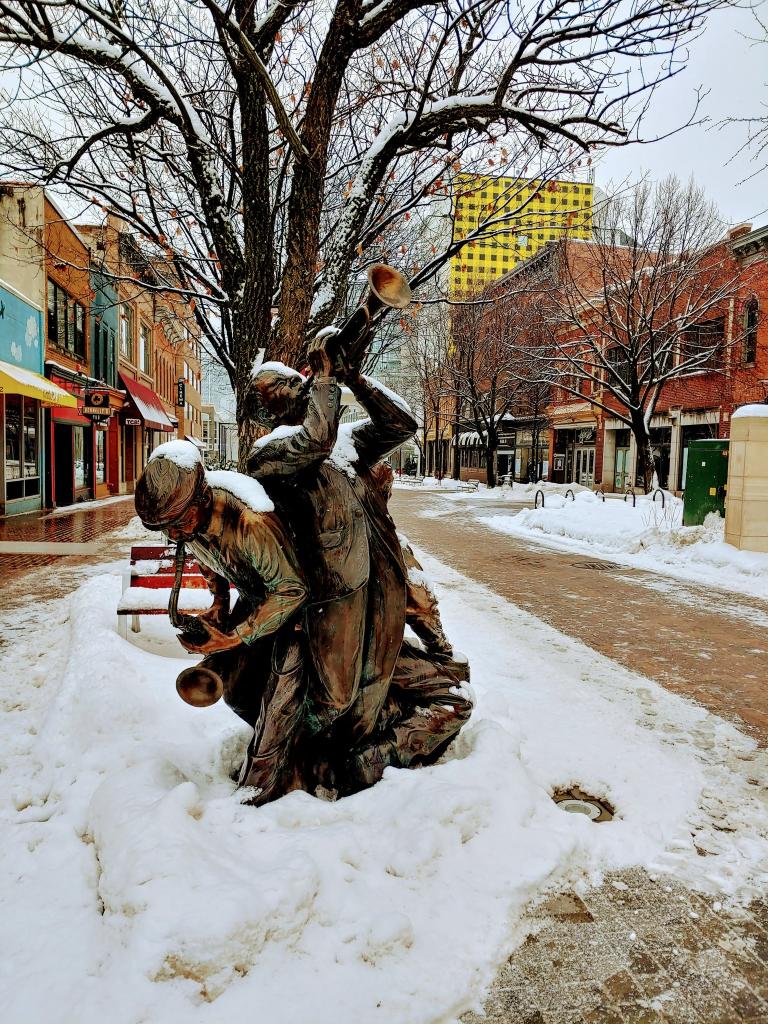 Snow covers statue of men playing saxiphones, downtown ped mall. 