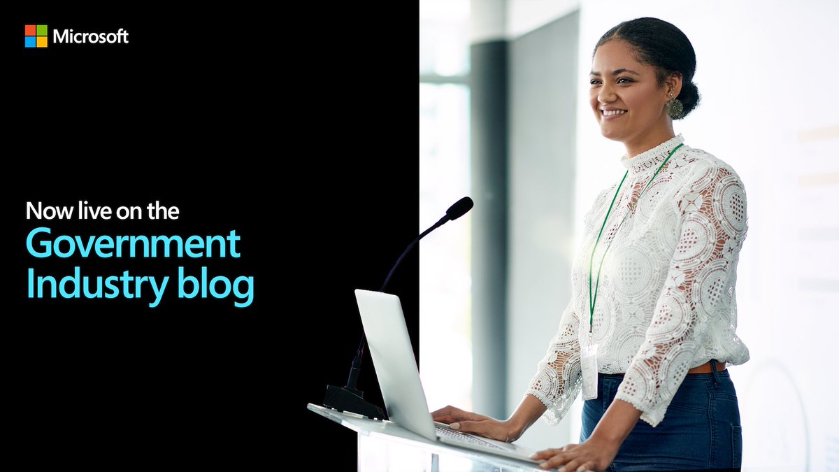Photo of a woman standing at a podium with an open laptop sitting on it.