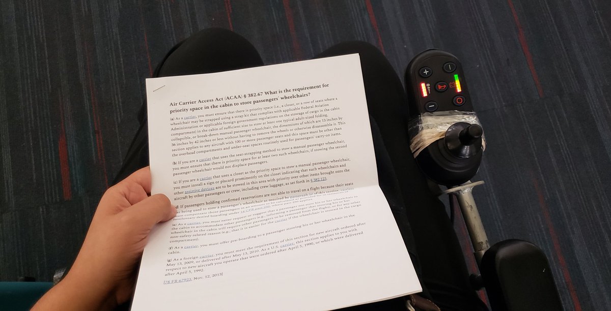 A copy of relevant sections of the ACAA on Annie's lap as she sits in a her powerchair with the controller taped and held together with rubber bands
