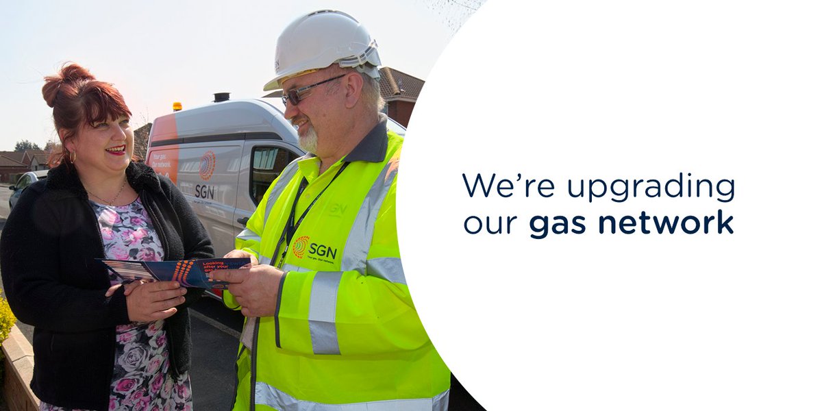 Gas engineer talking with female resident in a street.