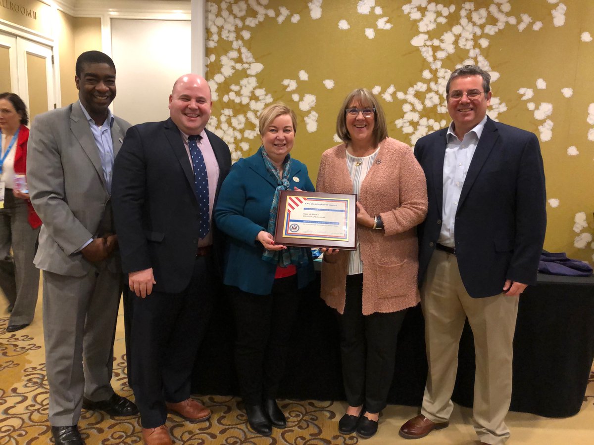 EAC Commissioners Tom Hicks, Christy McCormick, Ben Hovland and Don Palmer posing with Gail Fenumiai as she holds a Clearinghouse Award.