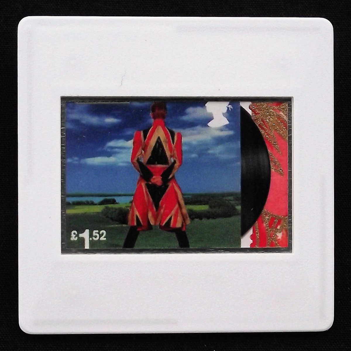 The image is of the album cover of Earthling printed on a Royal Mail postage stamp.  It has a breakout detail of a sliver of vinyl along the right hand perforated edge which is enhanced with a red and gold Yuzen paper.  The stamp is encased in a white framed slide mount.