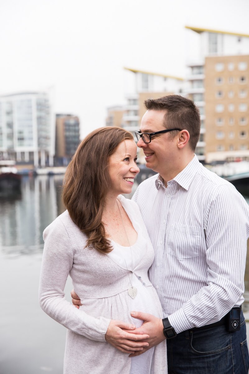 Expectant couple photographed by their home