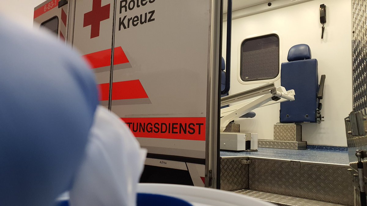 Desinfektionstuch vor seitlich geöffnetem Rettungswagen.