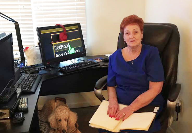 Patricia Foltz at her home office in Springfield, Ohio. Also pictured is her service dog, Koko.