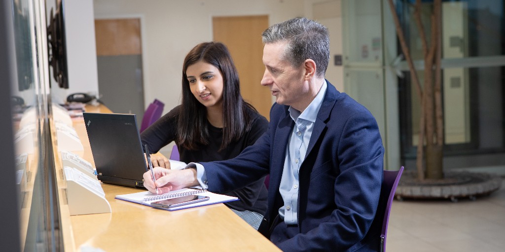 two people working on a laptop