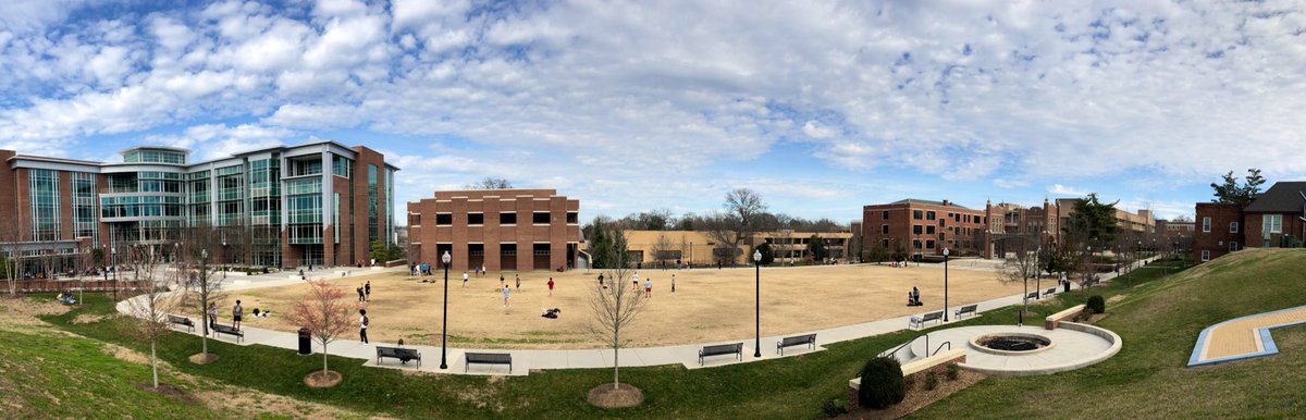 Panoramic view of Chamberlain Field where students are playing spike ball, frisbee and more.