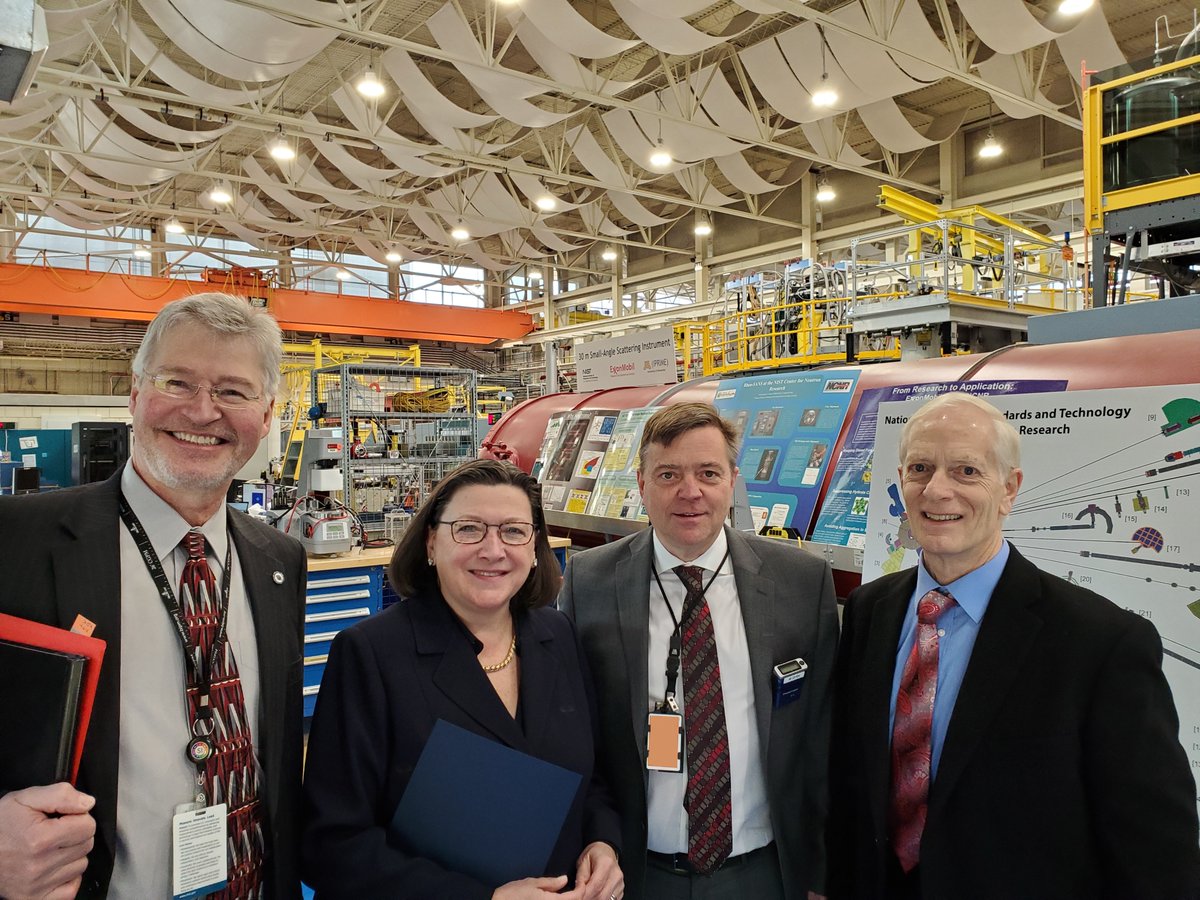 Group of people stand in large laboratory workspace.