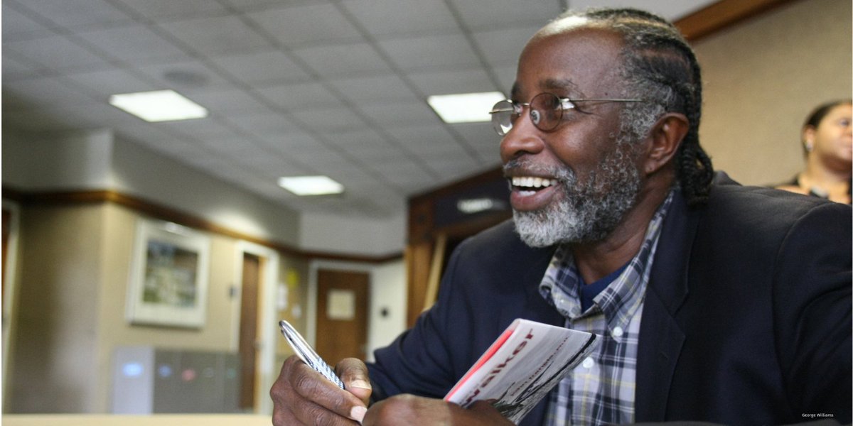 Dr. John Francis, smiling and looking up during a book signing where he is signing his book, "Planet Walker."