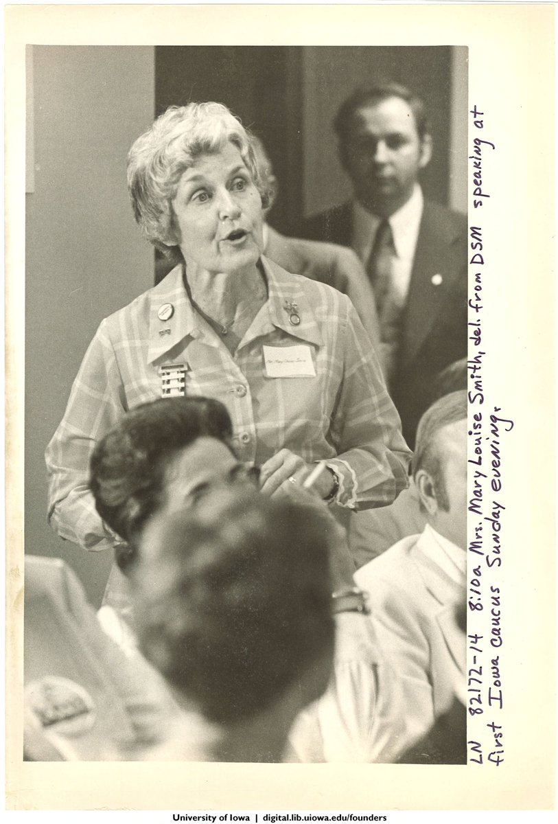 Black and white photo of Mary Louise Smith speaking at an Iowa Caucus location.