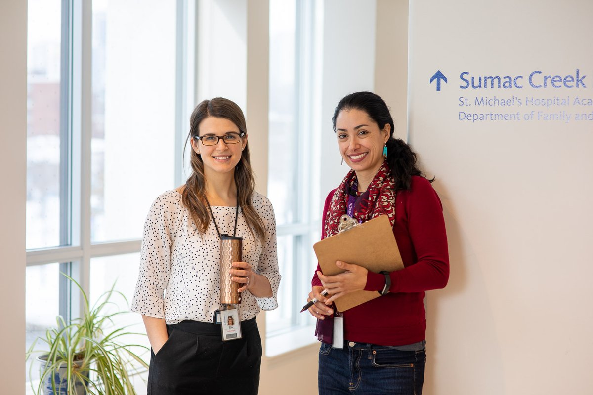 Two people standing in a brightly lit room