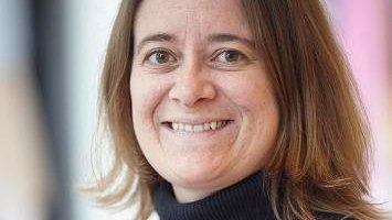 Sofia Branco headshot.  Smiling in pink- and blue-striped turtleneck.