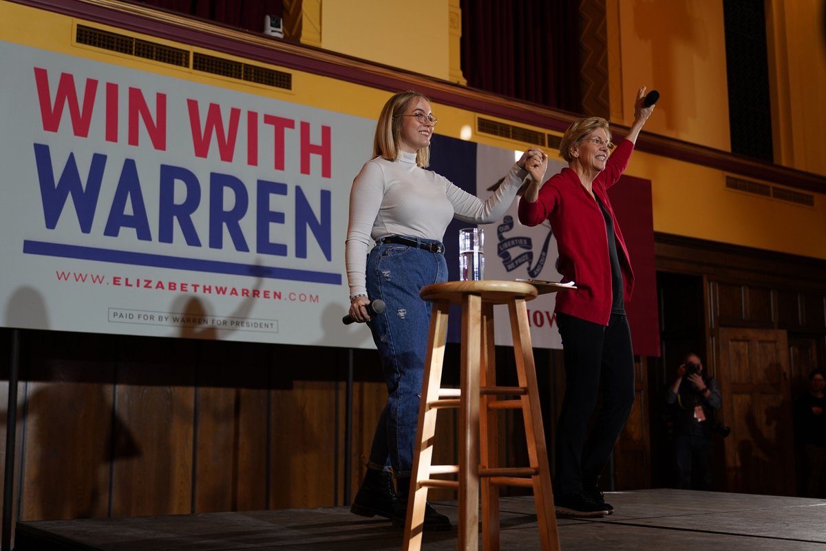 Elizabeth Warren waves on stage at the Ames town hall.