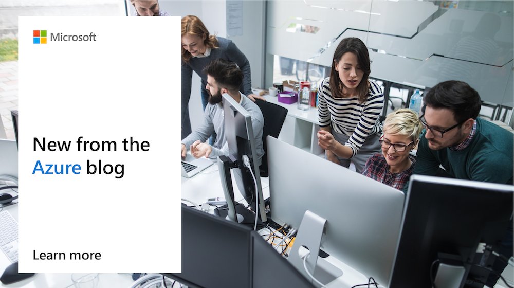 Photo of a number of people in conversation around a desktop.